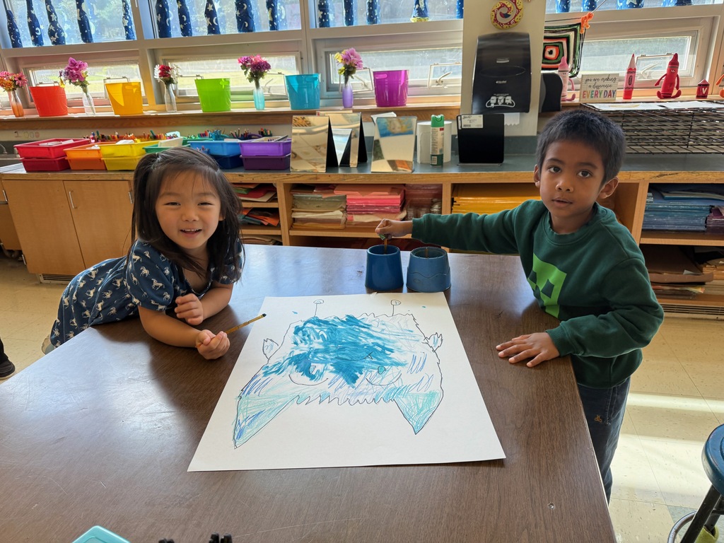 Two students painting together in the art room.