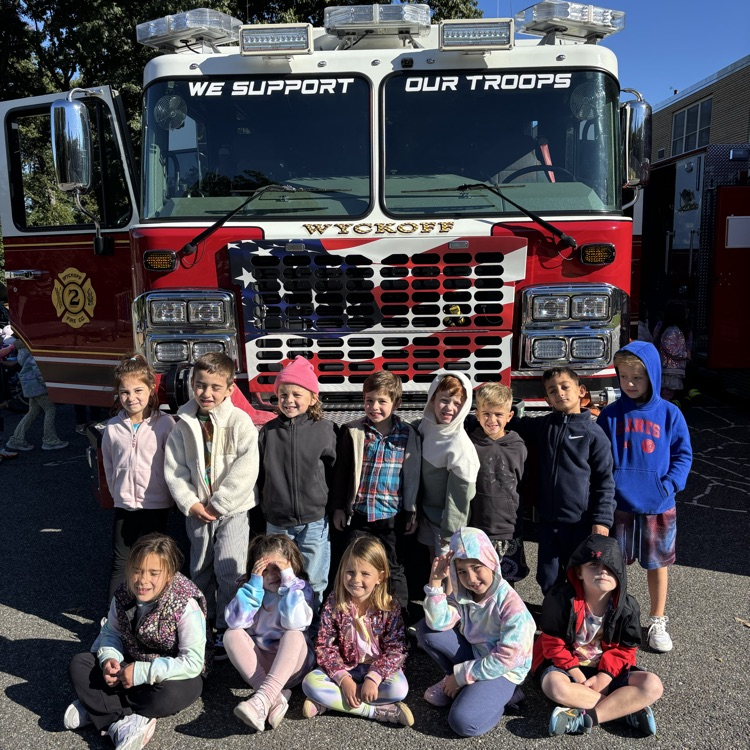 children standing in front of a firetruck