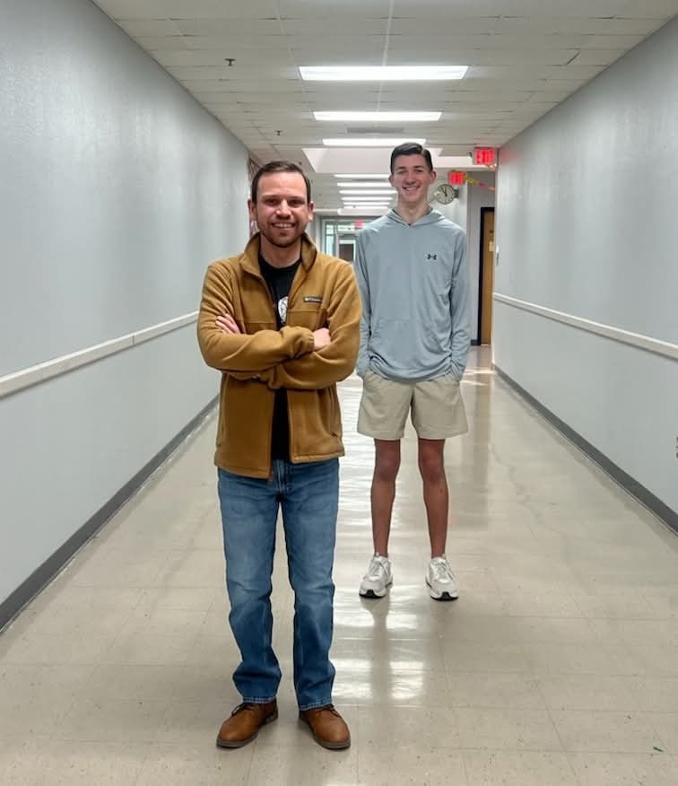 teacher standing next to student in hallway 