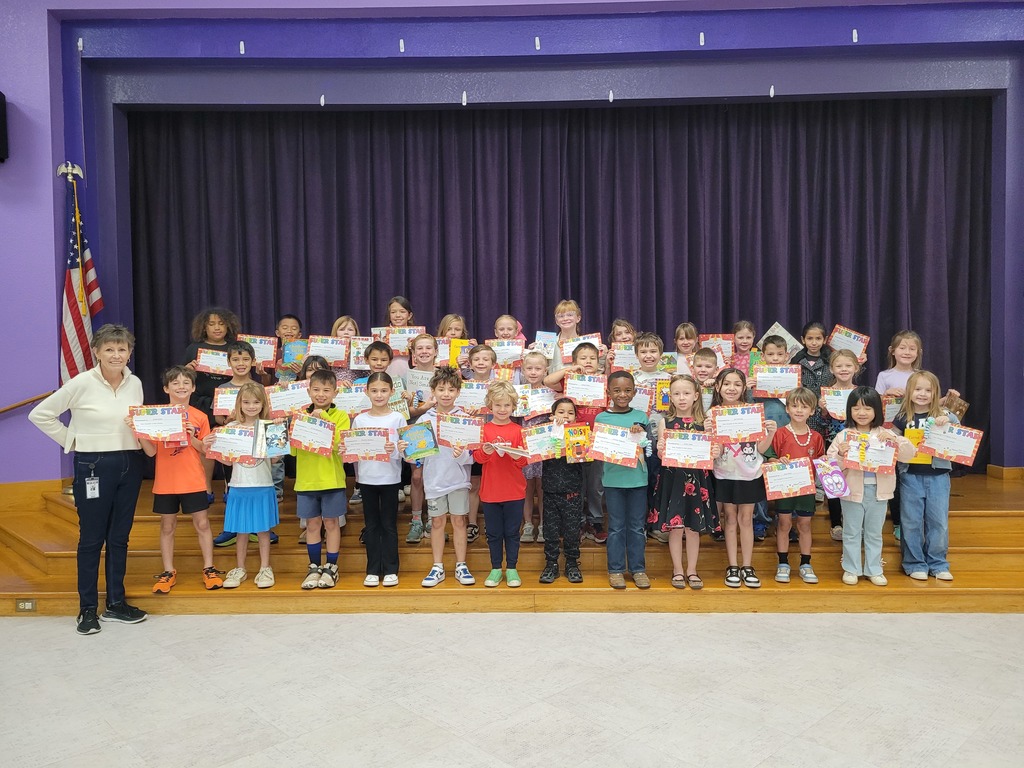 Wylie West Elementary Star Students pose on stage with their librarian, holding certificates and books to celebrate their reading achievements for the six weeks.
