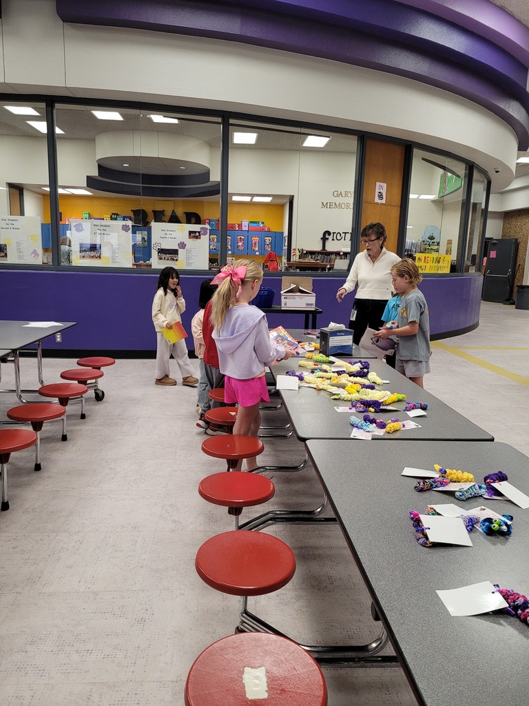 Wylie West Elementary students gather around tables near the library entrance, choosing reading prizes and visiting with their librarian during a reward celebration.