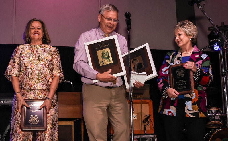Joey LIght presenting plaques to two teachers