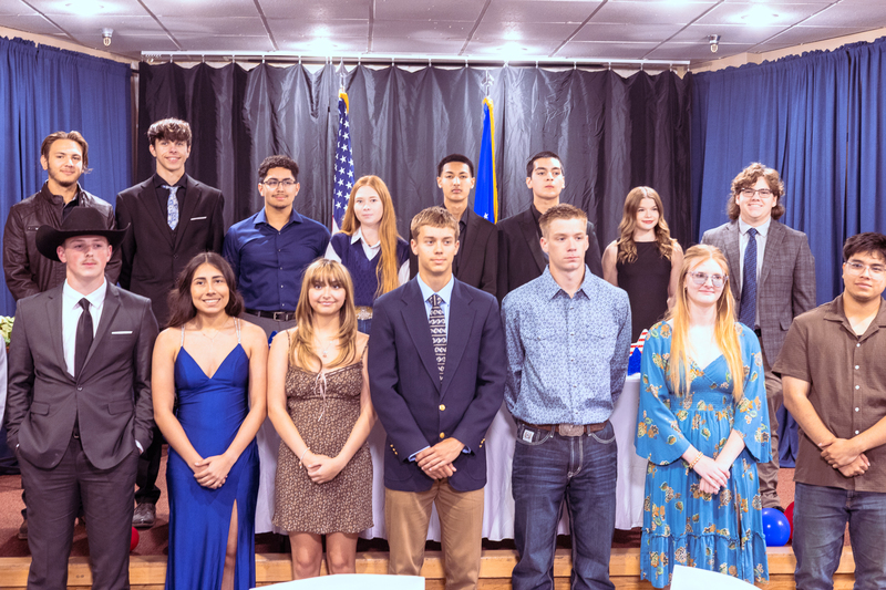 Group photo of students, families and staff standing together on stage for Military Signing Day.
