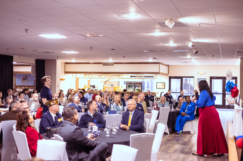 Wide view of families, students and guests seated at round tables during the Military Signing Day dinner.