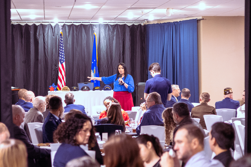 Guests seated and watching the ceremony in a decorated room with patriotic displays.