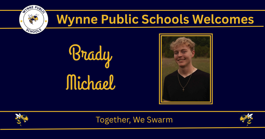 A blue banner welcomes Brady Michael to Wynne Public Schools. He wears a black shirt and a necklace.