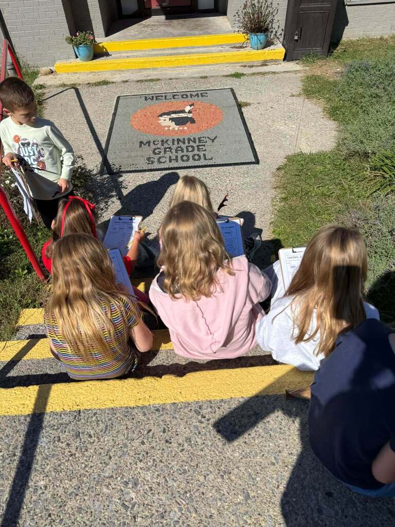 Students record their observastions on the front steps.