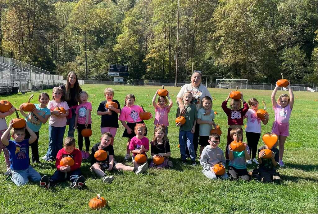Mrs. Bailey's class show off their pumkins on the football field.