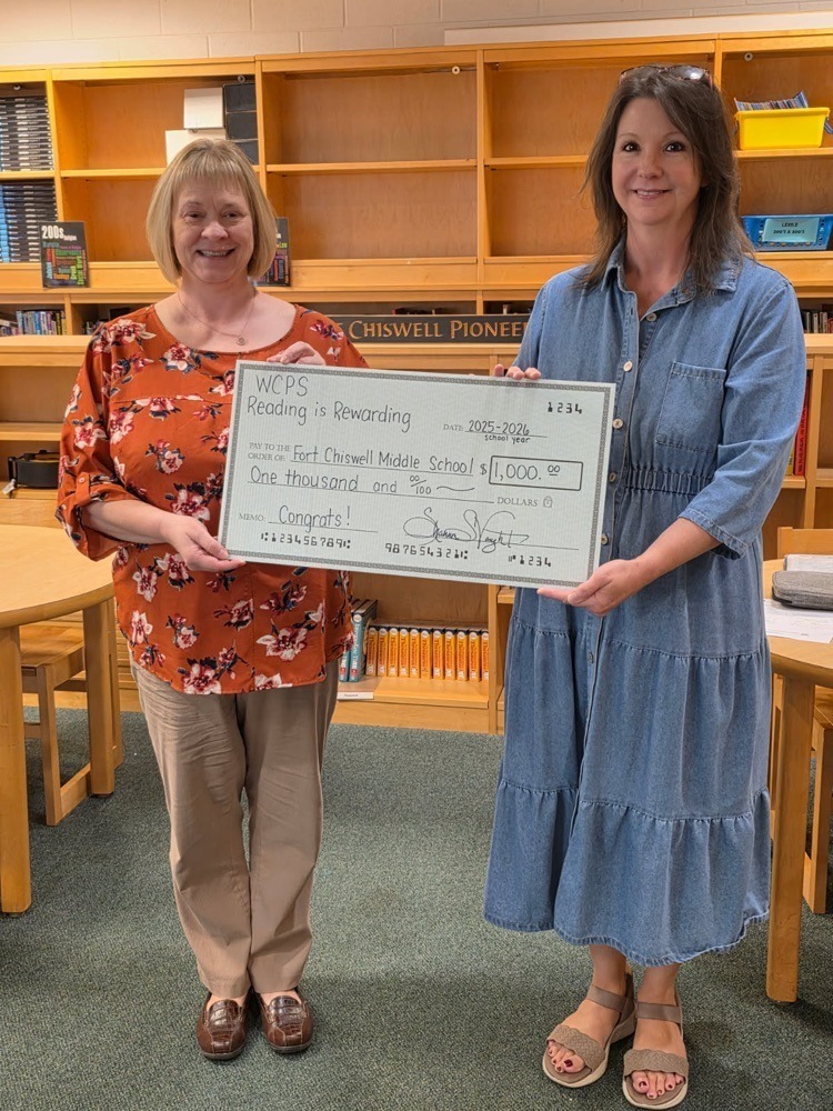 Corrina Harmon and Tammy Watson Holding $1000 check