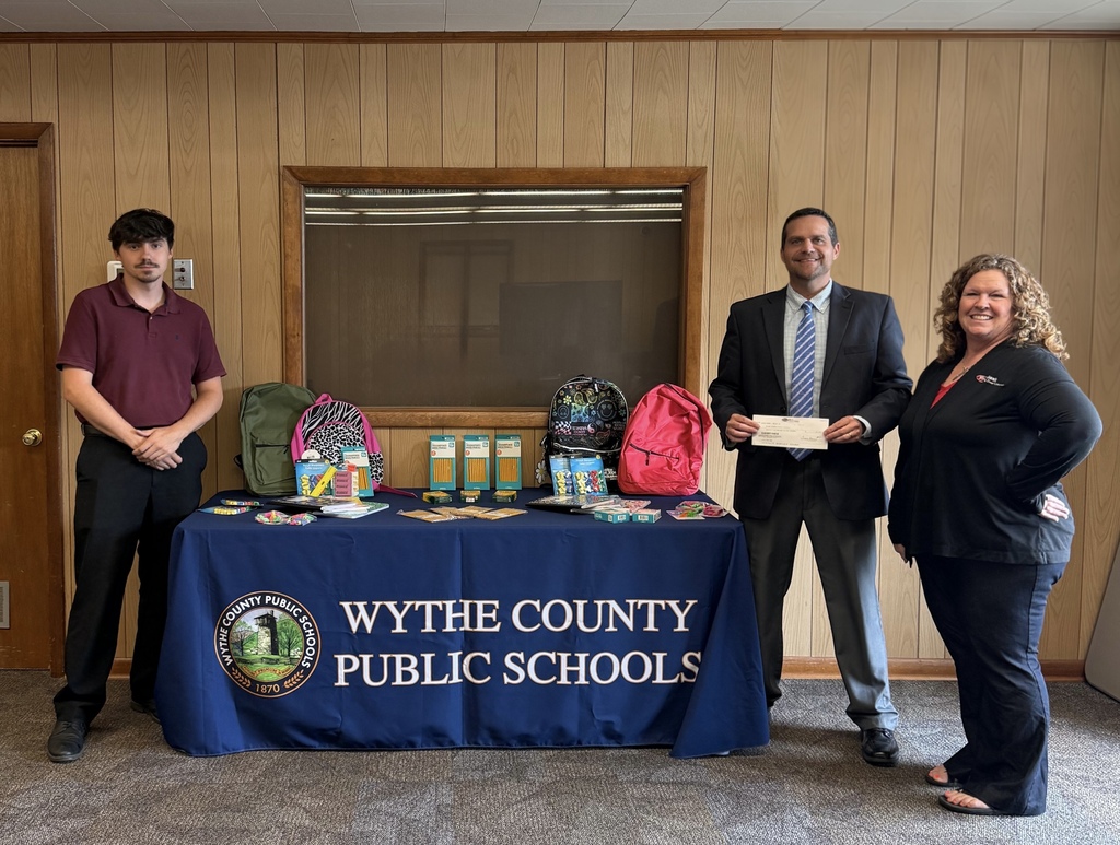 Superintendent Dr. Russell Street accepting a check donation and school supplies from First Bank & Trust for the Pack the Bus Drive.