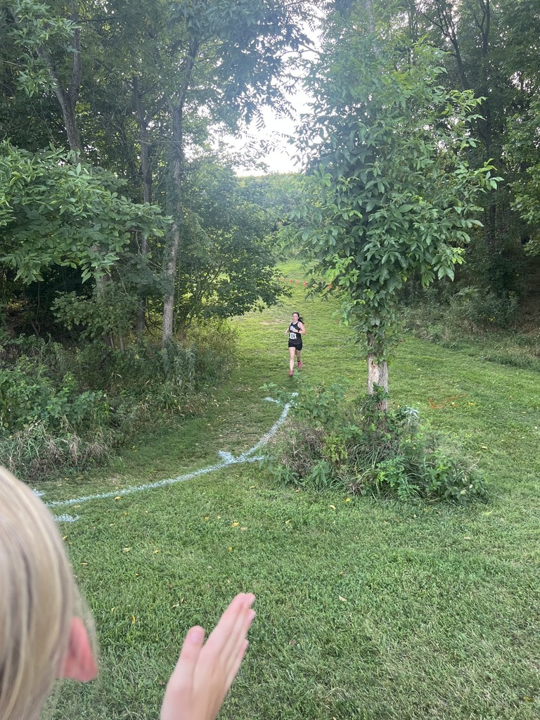 Female cross country runner follows the trail downhill.