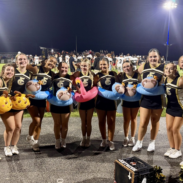 Cheerleaders pose wearing pool floats at the football game.
