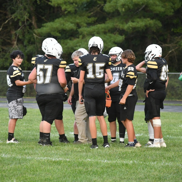 The JV football players bring water to the players on the field.