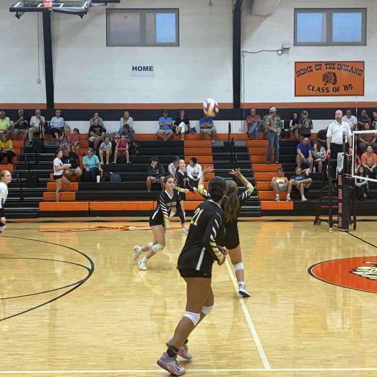 The hitters ready their feet as the setter receives the pass.