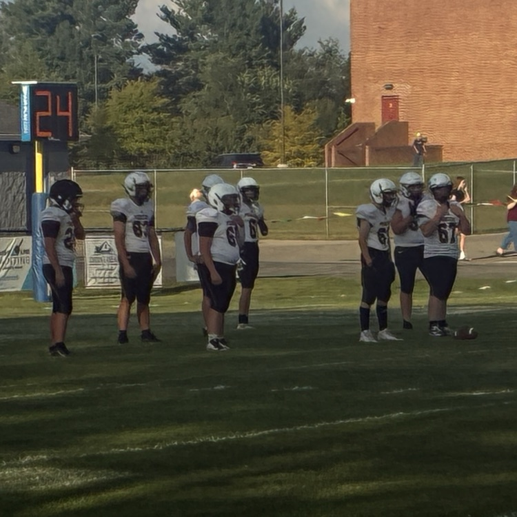 Football players move towards the line of scrimmage.