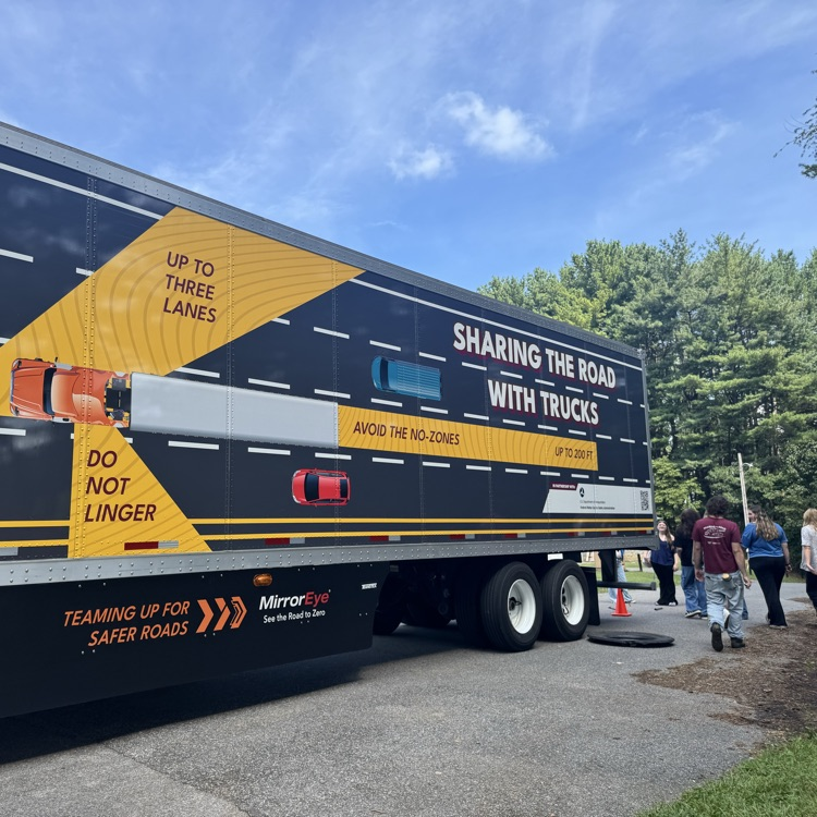 The truck says “Sharing the Road with Trucks” and shows do not linger zones.