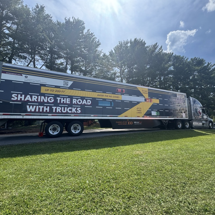 The truck says “Sharing the Road with Trucks” and shows do not linger zones.