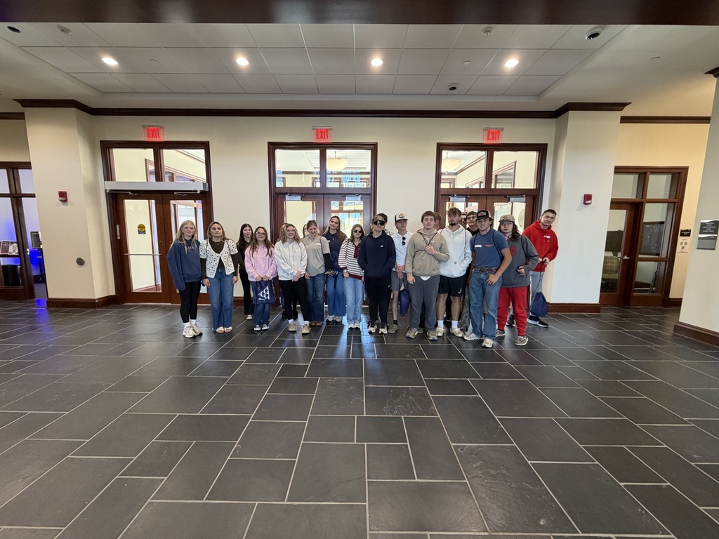 Students get together outside classrooms in a building lobby.