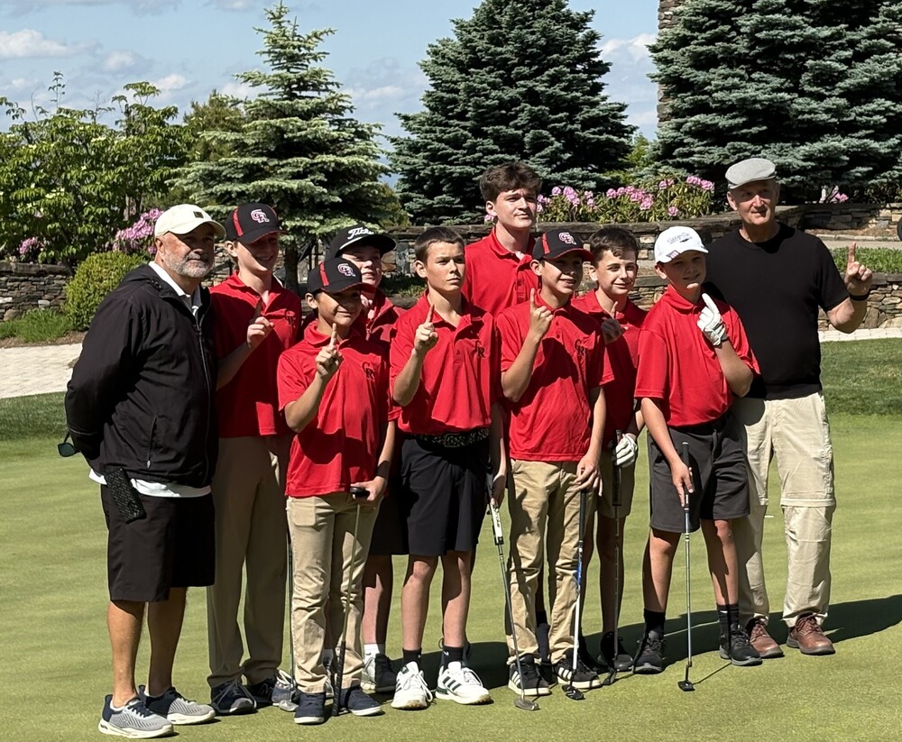 two coaches and eight boys in red polos holding up number 1 on their fingers
