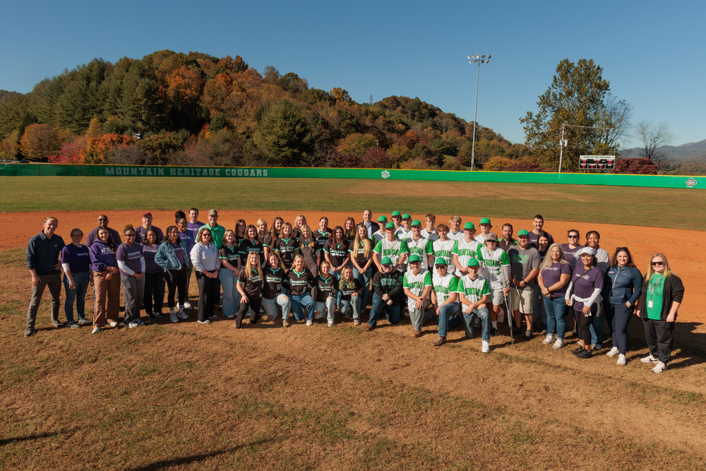 group of high school softball and baseball players posing with adults around them