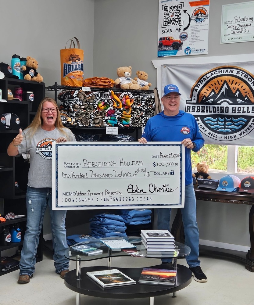 a woman and man holding a large check