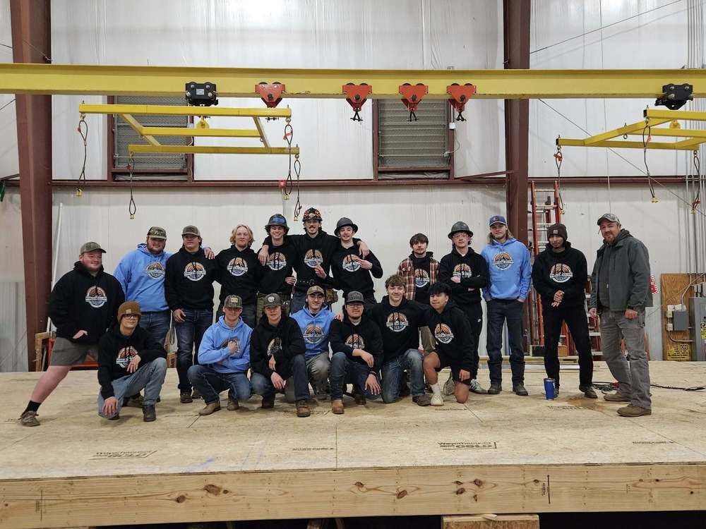 large group of high school boys standing on a construction platform