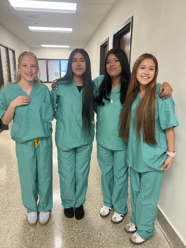 four girls in green scrubs smiling