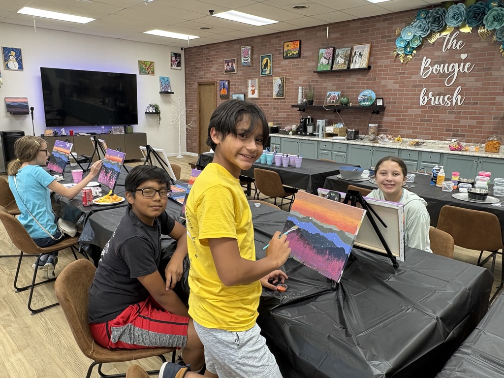 boy painting mountain scenery, other girls and boys in the background also painting
