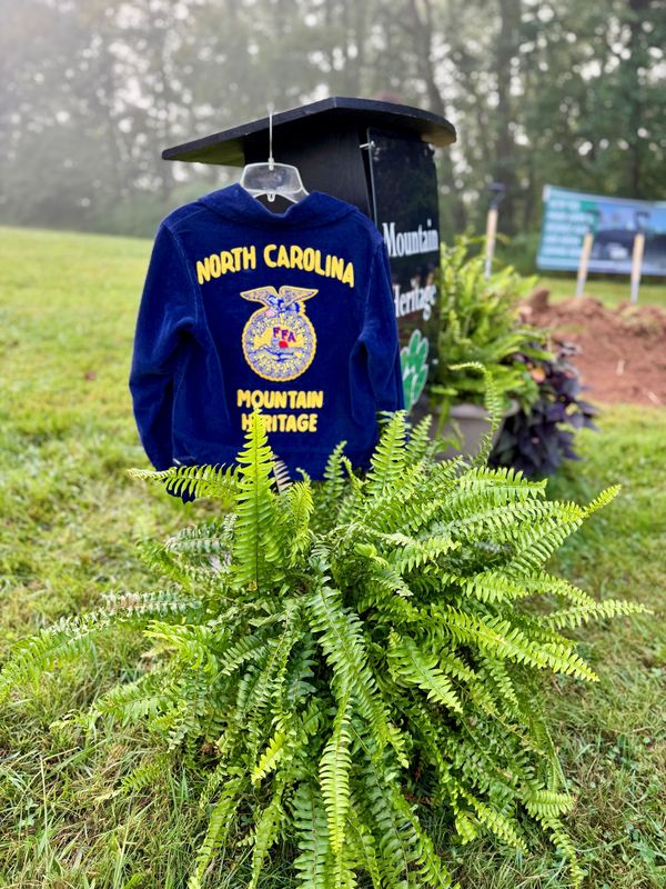 FFA jacket hanging on podium behind a fern