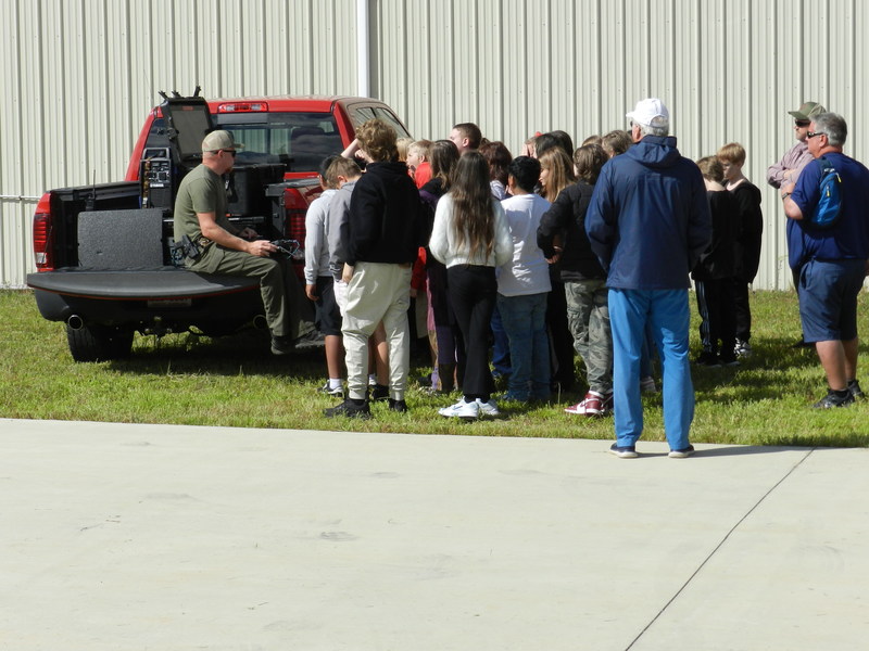 students looking on as a man operates a drone