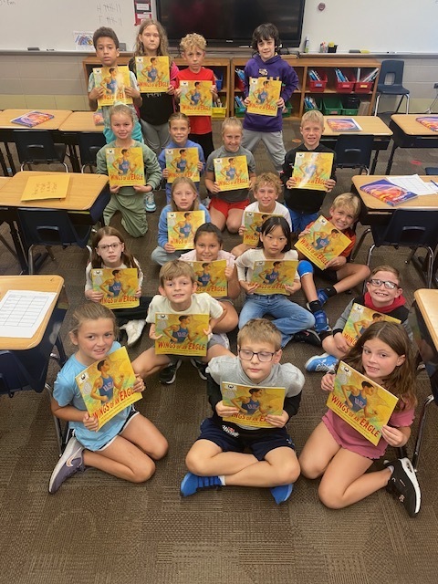 students holding books in their classroom