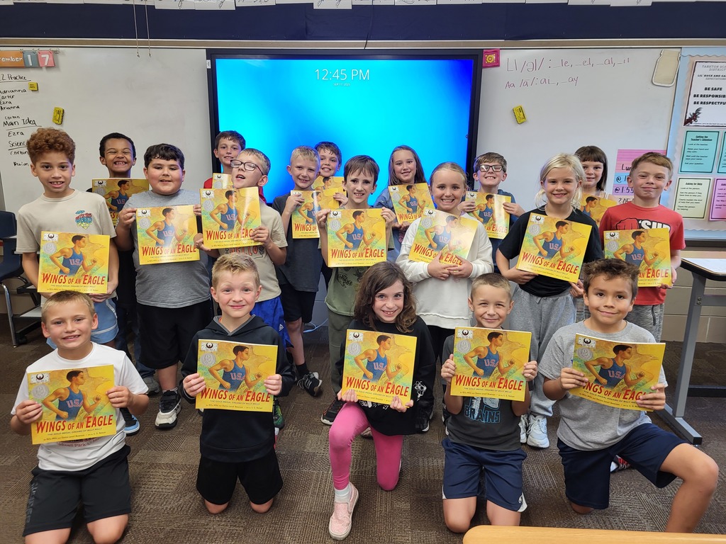 Smiling children holding gold books