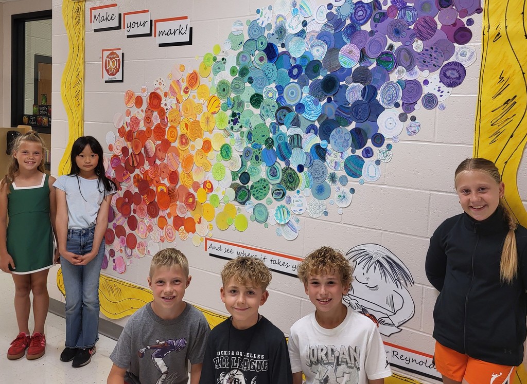 6 students standing by color dot artwork