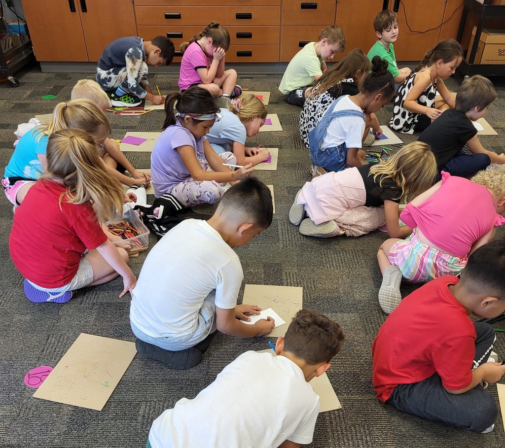 1st graders drawing on the carpet