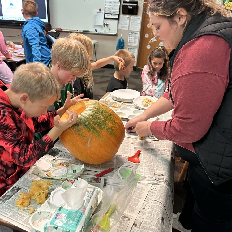 kids digging seeds out of a pumpkin