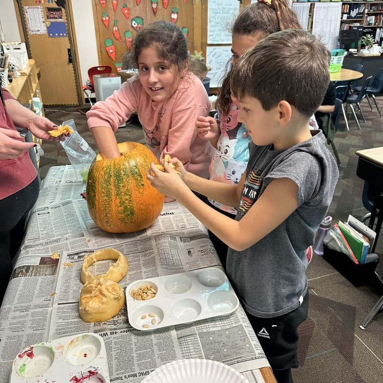 kids digging seeds out of a pumpkin