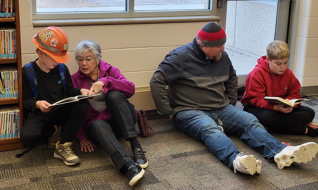 people sitting by windows reading books