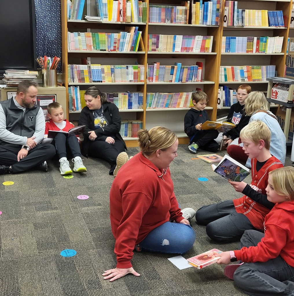 Families sitting on the floor reading