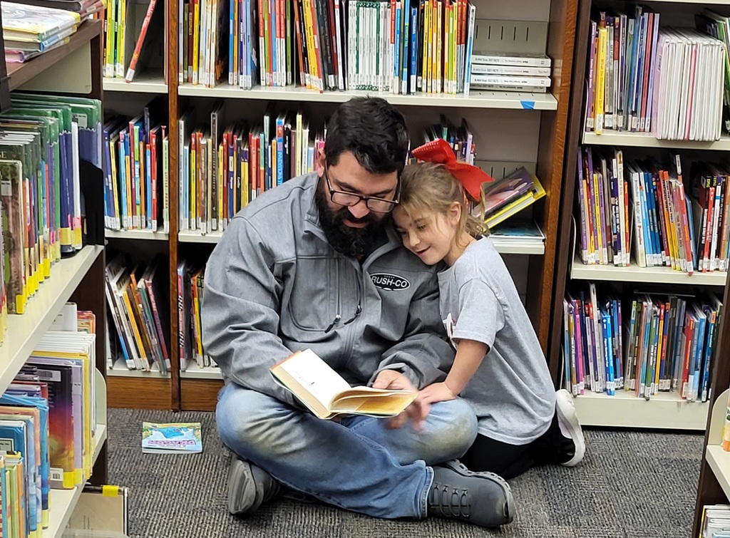 Father and daughter reading book together