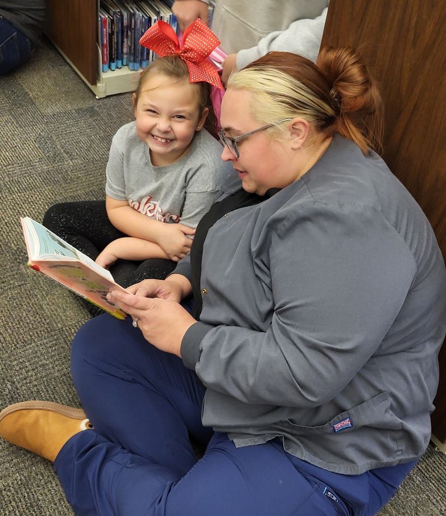 girl and woman sitting and reading