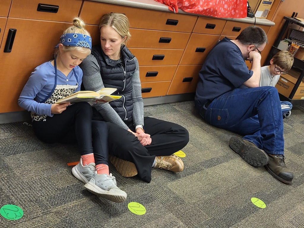 girl reading to mother sitting on the floor