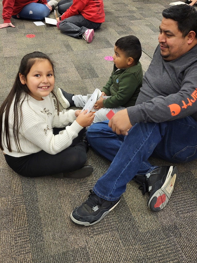 girl reading to father and younger brother