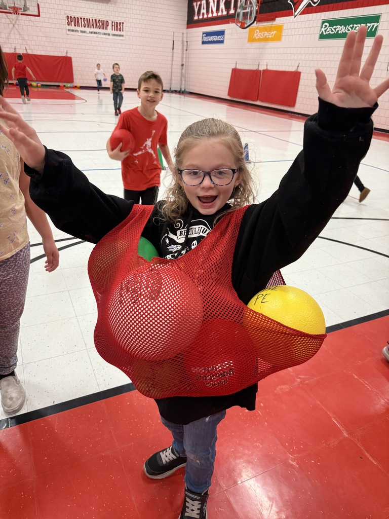 2nd graders smiling with recess balls stuffed in their jersey.
