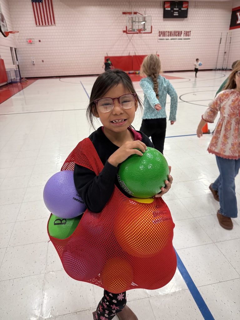 2nd graders smiling with recess balls stuffed in their jersey.