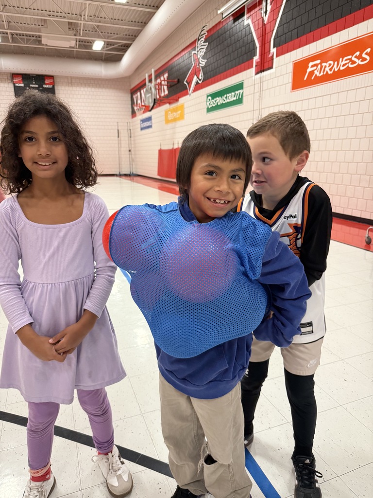 2nd graders smiling with recess balls stuffed in their jersey.