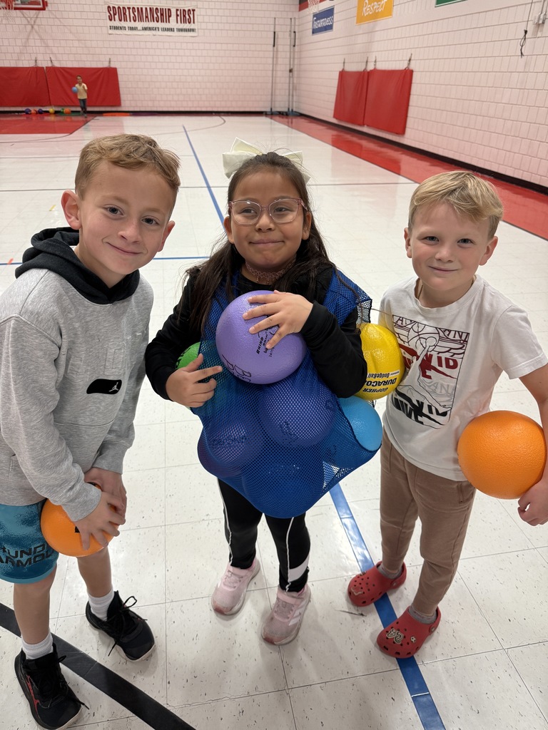 2nd graders smiling with recess balls stuffed in their jersey.