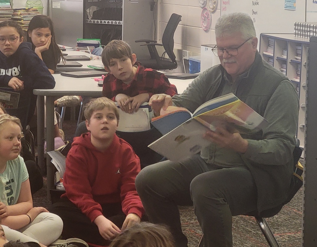 Man reading books to students
