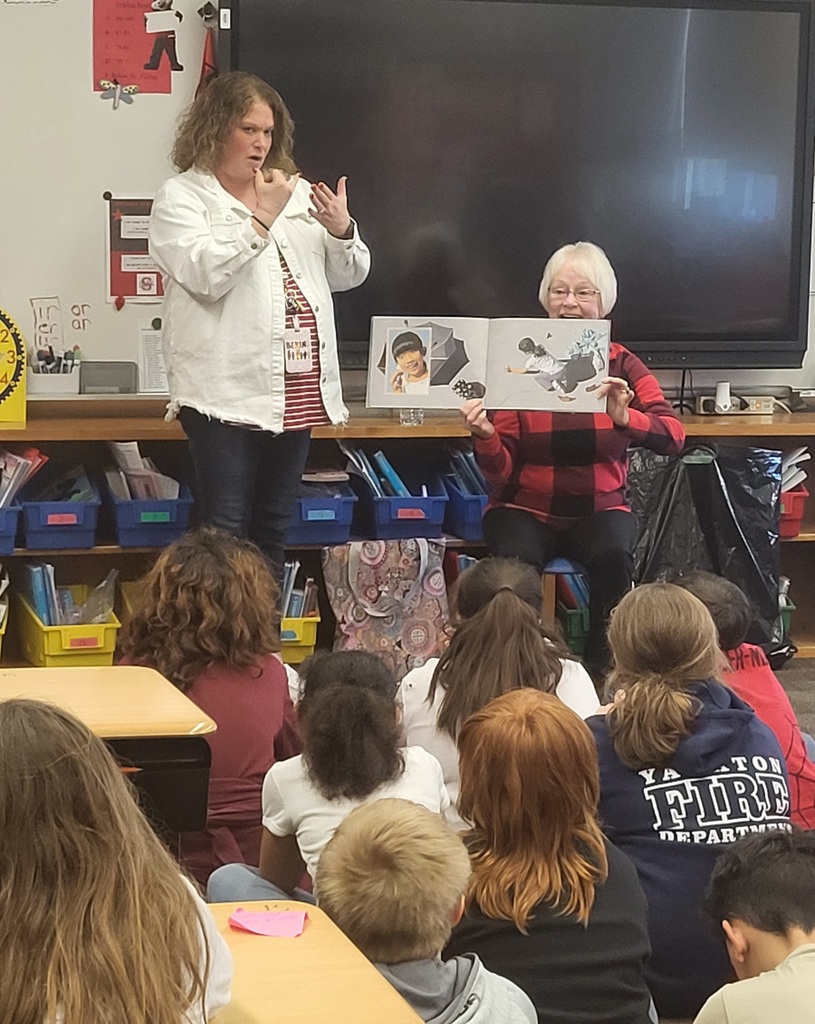 Woman and sign language interpreter reading book 