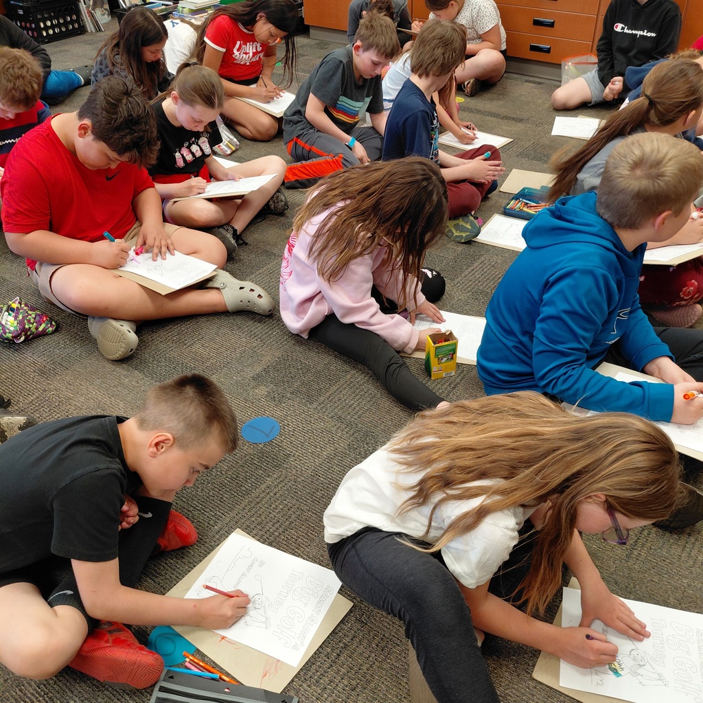 Students coloring seated on the floor