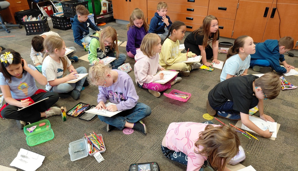 Children drawing while seated on the floor